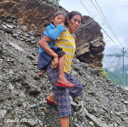 पहिराेबाट बचाउन बालबालिका बाेकेरै विद्यालय तिर आमाहरु